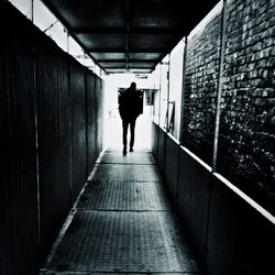 Rear view of people walking in alley