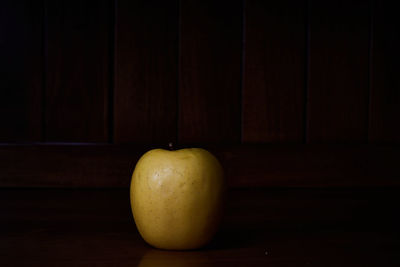 Close-up of apple on table against black background