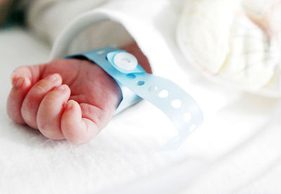 Cropped hand of newborn baby with name tag