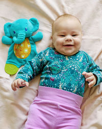 Smiling three month old baby in pink pants on a diaper. top view.