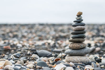 Stack of pebbles on beach against sky