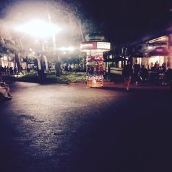 People standing on illuminated city street at night