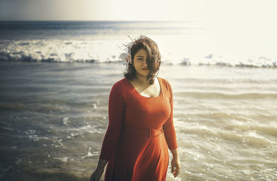 Woman standing at beach against sky