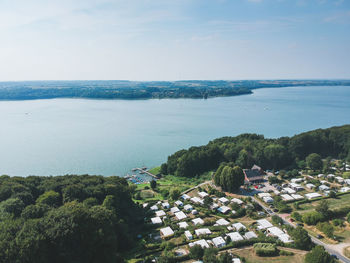 High angle view of townscape by sea against sky