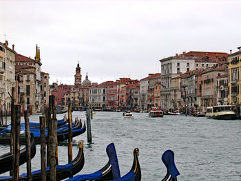 Boats in canal by buildings in city