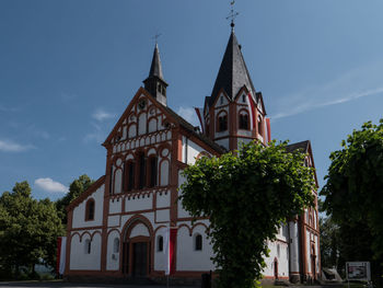 Low angle view of trees and building against sky