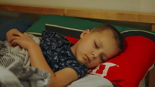 High angle view of boy sleeping on bed at home