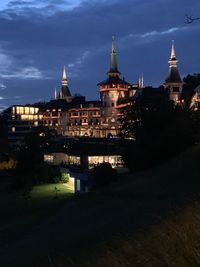 Illuminated buildings against sky at dusk
