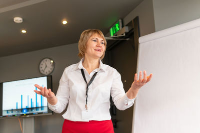 Mid adult woman standing against wall