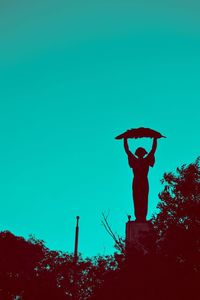 Low angle view of statue against clear blue sky