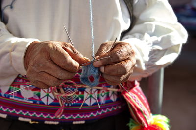 Midsection of bride and bridegroom holding hands