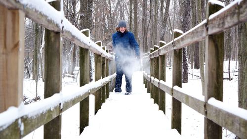 Happy woman on wooden footbridge during winter