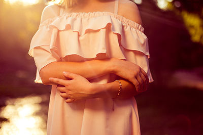 Midsection of woman standing by cross