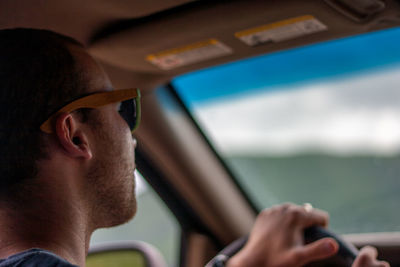 Close-up of young man riding car