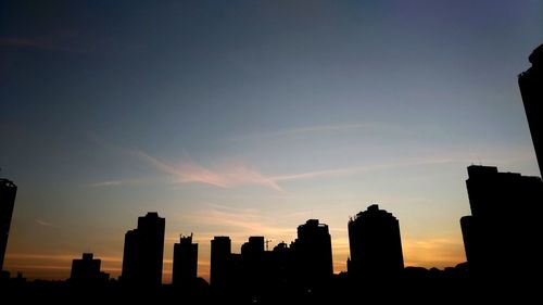 Silhouette buildings against sky during sunset