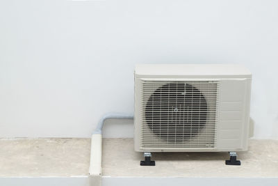 Close-up of air conditioner against white wall