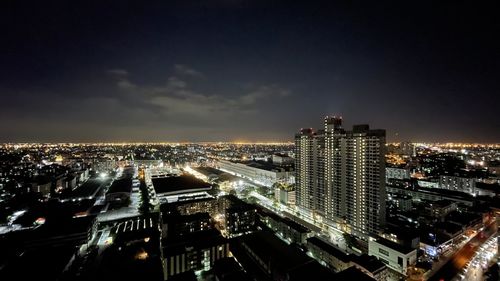 High angle view of illuminated city against sky at night