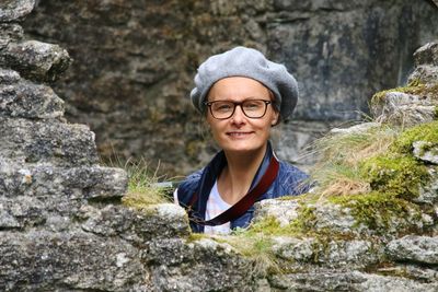 Portrait of smiling young woman standing on rock