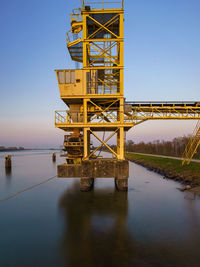 Bridge over sea against clear sky during sunset