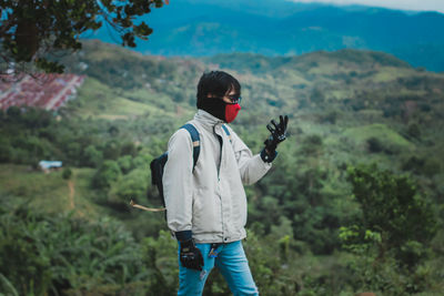 Side view of man standing against mountain