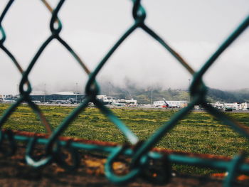 Surface level of chainlink fence against sky