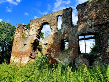 Low angle view of old abandoned building against sky