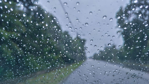 Close-up of wet glass window during rainy season