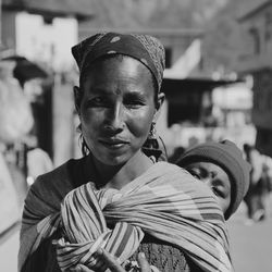 Portrait of woman carrying baby in sling