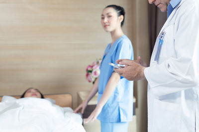 Midsection of doctor examining patient in hospital