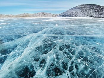 Aerial view of snowcapped mountain by lake baikal against sky