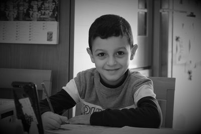 Portrait of smiling boy sitting at home