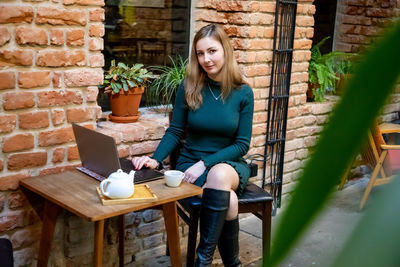 Portrait of beautiful woman using laptop while sitting at cafe