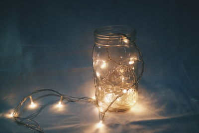Close-up of illuminated lights in jar on table