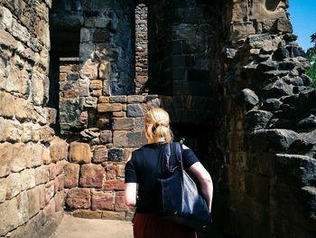 Person standing on stone wall