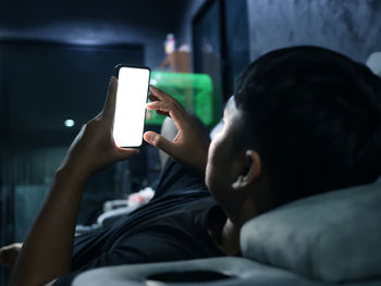 Midsection of man using mobile phone in bus