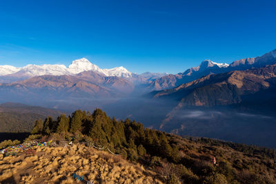 Scenic view of snowcapped mountains against blue sky