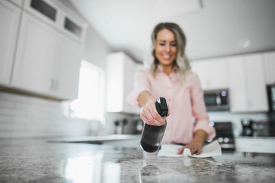 Low angle view of woman cleaning kitchen counter at home