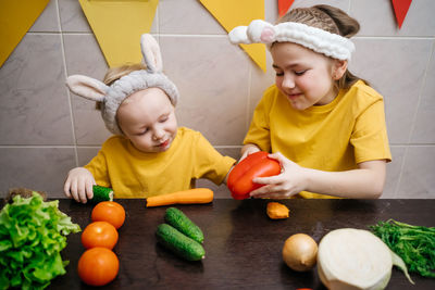 Children in rabbit ears eat herb dill vegetables easter. high quality photo