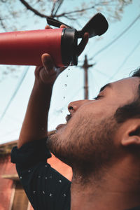 Close-up portrait of young man holding mobile phone