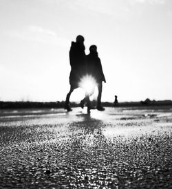 Silhouette of people in water at sunset