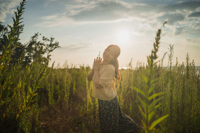 Woman standing on field against sky