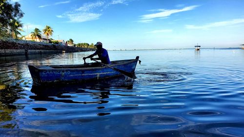 Man fishing in sea against sky