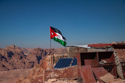 Flag by building against clear blue sky