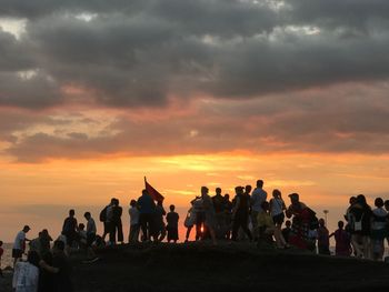 Silhouette people against sky during sunset