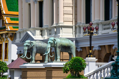 Statue against building in city