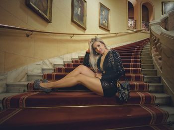 Portrait of woman sitting on staircase at home