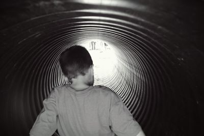 Rear view of boy playing in slide