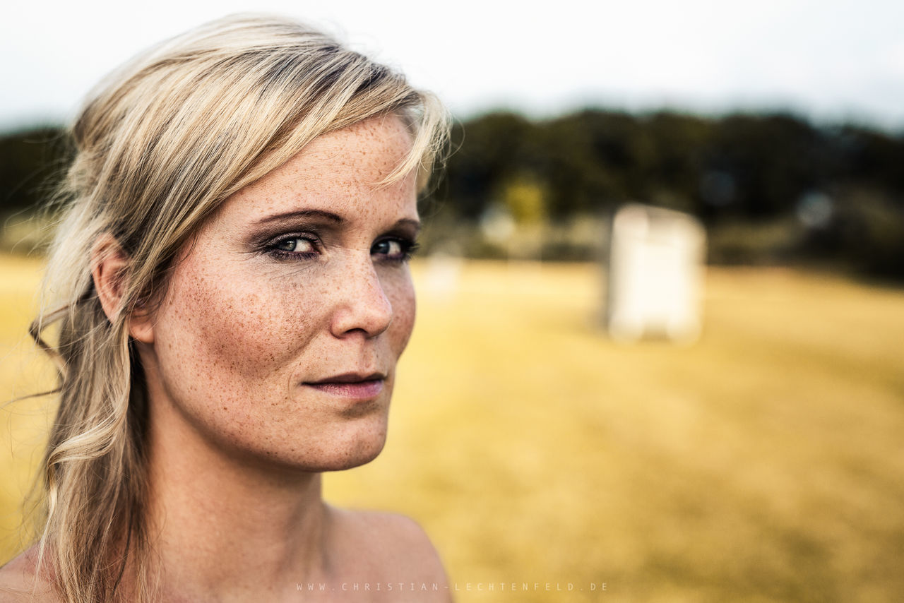 headshot, portrait, one person, blond hair, hair, real people, women, focus on foreground, hairstyle, adult, females, close-up, lifestyles, looking at camera, looking, beauty, day, beautiful woman, human face, contemplation