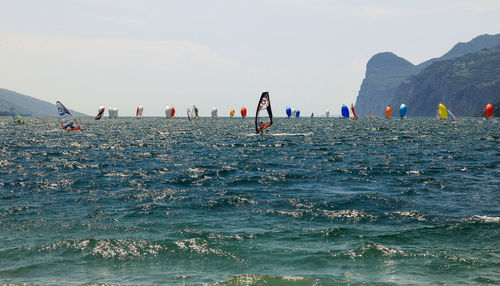 People windsurfing in sea against clear sky