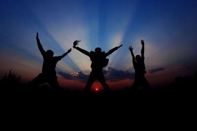Silhouette people against sky during sunset